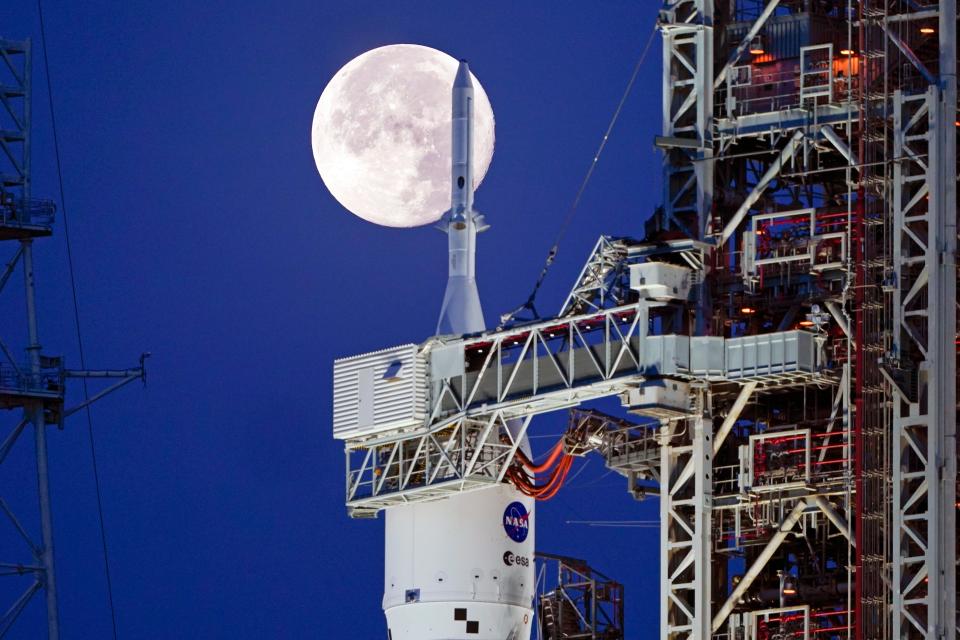 The Strawberry Supermoon sets in front of the NASA Artemis rocket with the Orion spacecraft aboard on pad 39B at the Kennedy Space Center, Wednesday, June 15, 2022, in Cape Canaveral, Fla. Artemis is undergoing tests at the pad before an unmanned mission to the moon.