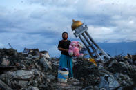 A woman holds a stuffed rabbit toy after it was found at her destroyed house where she said she had lost her three children after the area was hit by an earthquake, in Palu, Central Sulawesi, Indonesia, October 7, 2018. REUTERS/Jorge Silva/File photo