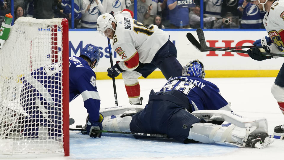 Tampa Bay Lightning goaltender Andrei Vasilevskiy (88) and defenseman Mikhail Sergachev (98) team up to stop a shot by Florida Panthers center Aleksander Barkov (16) during the third period in Game 4 of an NHL hockey second-round playoff series Monday, May 23, 2022, in Tampa, Fla. (AP Photo/Chris O'Meara)