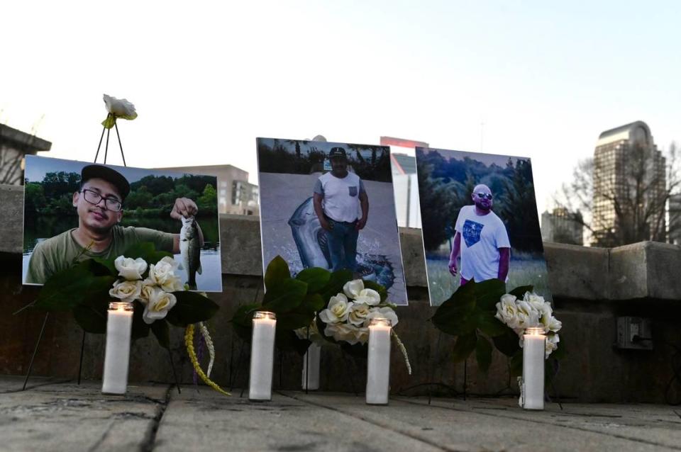 Candles are lit below the photographs of the three men who died when the scaffolding collapsed at a Charlotte, NC construction site in early January 2023. Friends and family gathered on Friday, February 3, 2023 at Marshall Park for a candlelight vigil.