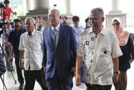 Former Malaysian Prime Minister Najib Razak, center, walks with his supporters as he arrives at Kuala Lumpur High Court in Kuala Lumpur, Malaysia, Wednesday, Aug. 28, 2019. His second trial is due to begin Wednesday. (AP Photo/Vincent Thian)