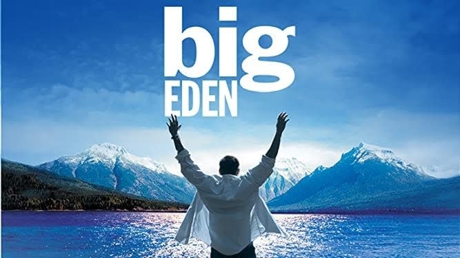 A person with raised arms stands before a lake framed by mountains and under the text "big EDEN"