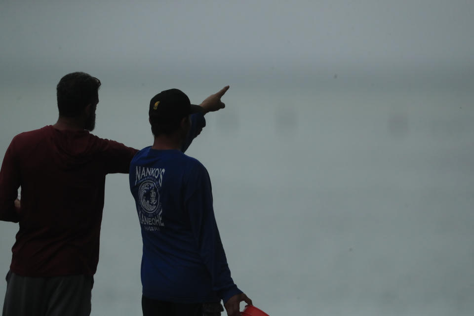 Residents look at a downed U.S. Navy aircraft in Kaneohe Bay, Monday, Nov. 20, 2023, in Kaneohe, Hawaii. (Jamm Aquino/Honolulu Star-Advertiser via AP)