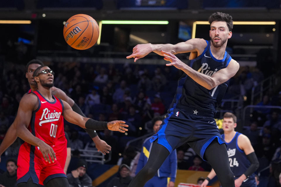 Chet Holmgren, right, of the Oklahoma City Thunder passes the ball in front of Scoot Henderson of the Portland Trail Blazers during the NBA Rising Stars basketball game in Indianapolis, Friday, Feb. 16, 2024. (AP Photo/Michael Conroy)