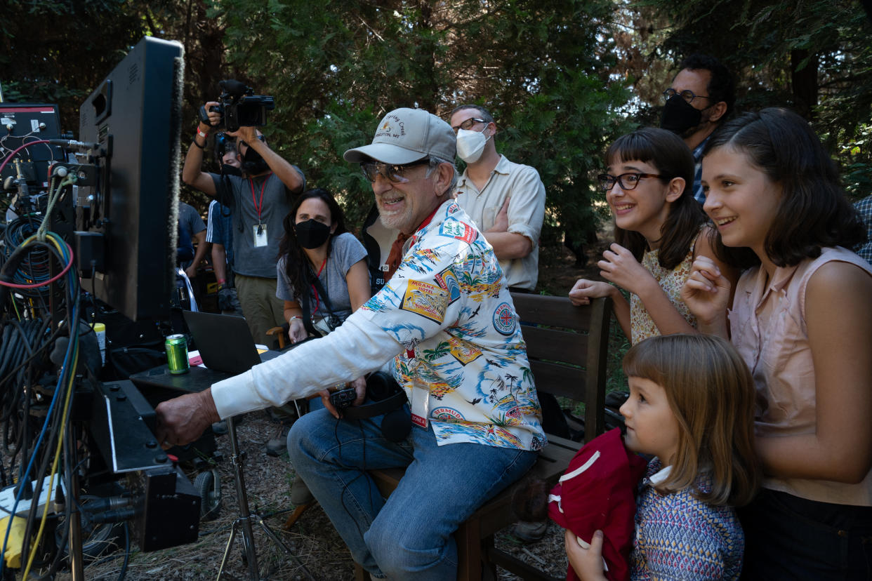 (from left background) Producer Kristie Macosko Krieger, co-writer/producer/director Steven Spielberg, Seth Rogen, Julia Butters, co-writer/producer Tony Kushner, Keeley Karsten and Sophia Kopera on the set of The Fabelmans. 