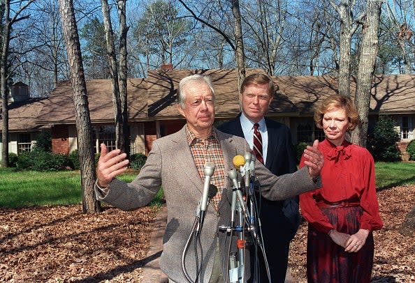 Former US President Jimmy Carter (L) addresses media 01 March 1988 outside Carter's residence in Plains while Democratic party presidential hopeful Richard Gephardt (C) and Rosalynn Carter look on. (AFP via Getty Images)