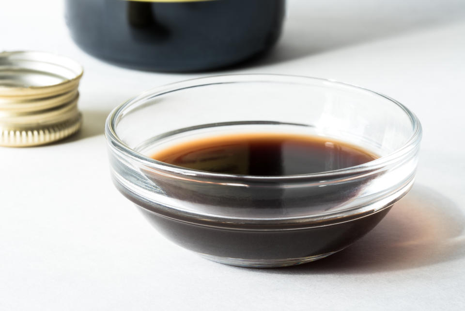 Balsamic vinegar in a glass dish on top of a white background