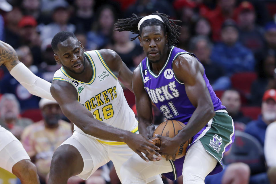 Houston Rockets forward Usman Garuba (16) attempts to strip the ball from Milwaukee Bucks guard Jrue Holiday (21) during the first half of an NBA basketball game Sunday, Dec. 11, 2022, in Houston. (AP Photo/Michael Wyke)