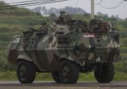 Malaysian soldiers drive towards the area where the stand-off with Sulu gunmen is on going, in Tanduo village on March 4, 2013. Malaysian air and ground forces launched an assault on defiant Filipino intruders on Tuesday as the government moved to end a three-week incursion that had already killed 27 people