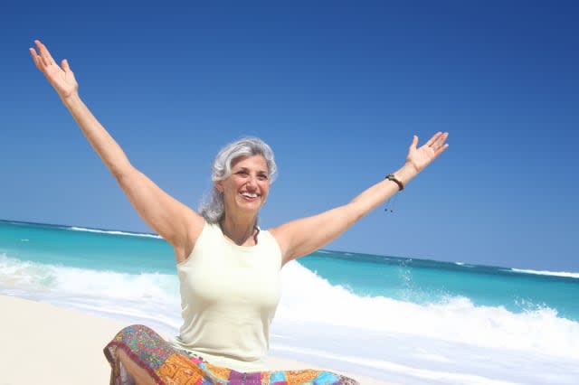 Cheerful senior woman sitting at beach