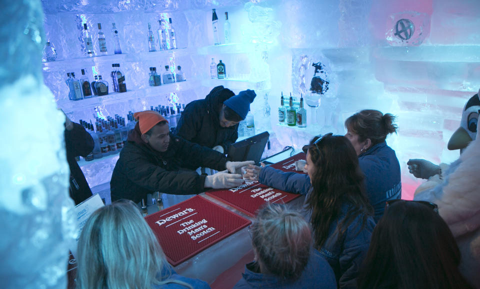 Drink mixers Udi Shakya, left, and Paul Stauros, right, serve drinks to customers at the Minus 5 ice bar, on Monday, July 8, 2013 in New York. The city’s first ice bar is now open at the Hilton Hotel on Sixth Avenue. Admission includes Eskimo-style gloves, parkas and boots for the privilege of drinking cocktails in the freezing Minus 5 Ice Bar. (AP Photo/Bebeto Matthews)