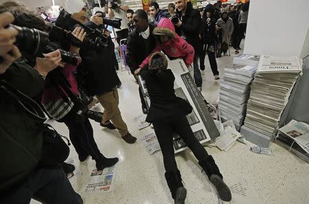 Shoppers wrestle over a television as they compete to purchase retail items on "Black Friday" at an Asda superstore in Wembley, north London November 28, 2014. REUTERS/Luke MacGregor