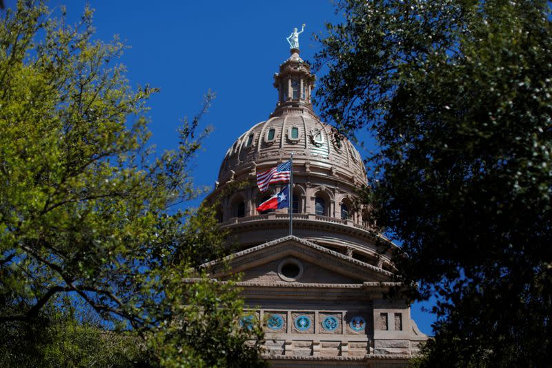 The U.S flag and the Texas State flag fly over the Texas State Capitol in Austin