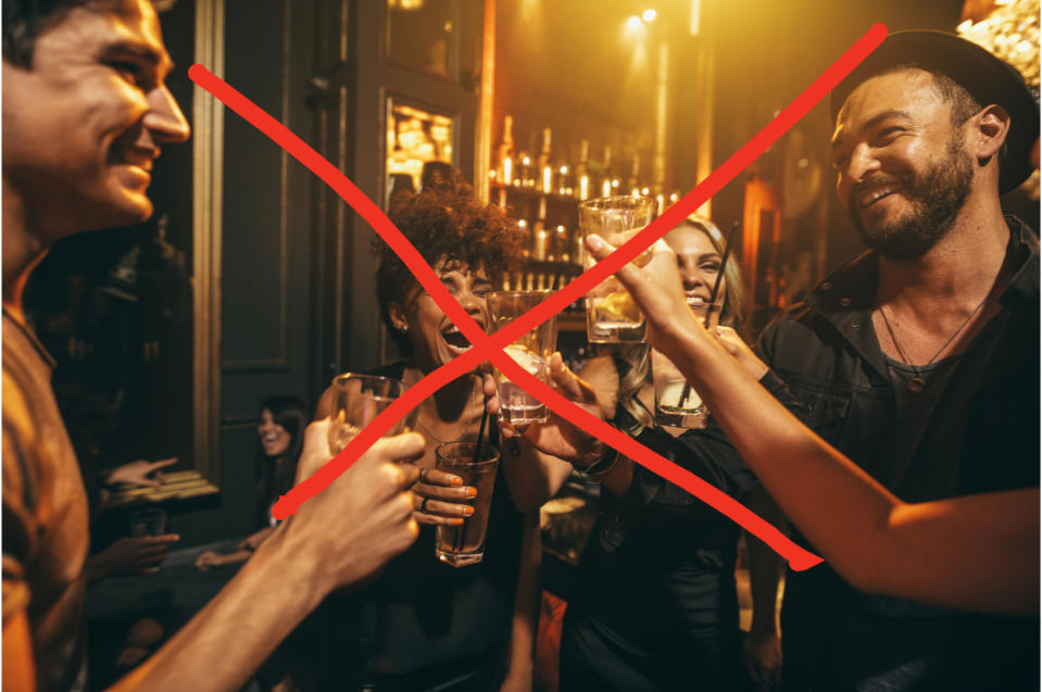 Group of people socializing with drinks, smiling, with a red cross indicating prohibition or an error