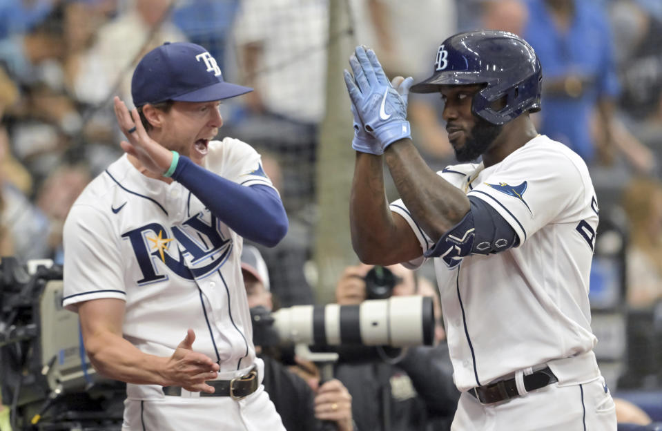 Tampa Bay Rays' Brett Phillips, left, greets Randy Arozarena at the dugout after Arozarena;s solo home run off Baltimore Orioles starter Dean Kremer during the third inning of a baseball game Saturday, July 16, 2022, in St. Petersburg, Fla. (AP Photo/Steve Nesius)