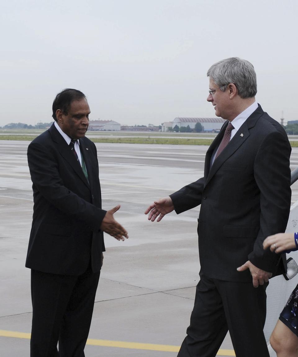 Canada's PM Harper is greeted by South Africa's DIRCO Deputy Minister Ebrahim at Waterkloof Airforce Base in Pretoria