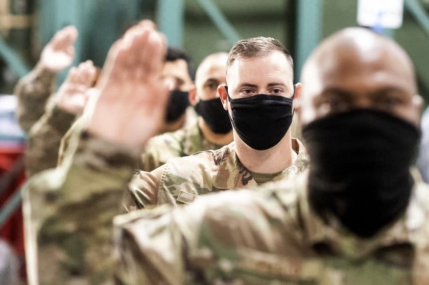 Master Sgt. Jeffery Health takes an oath during a ceremony for U.S. Air Force airmen transitioning to U.S. Space Force guardian designations on Friday, Feb. 12, 2021, at Travis Air Force Base, Calif. (AP Photo/Noah Berger)