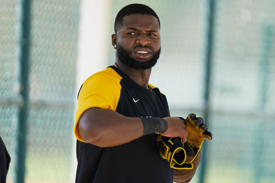 Gregory Polanco de los Piratas de Pittsburgh se calza los guantes durante una práctica de bateo, el jueves 25 de febrero de 2021, en Bradenton, Florida (AP Foto/Frank Franklin II)