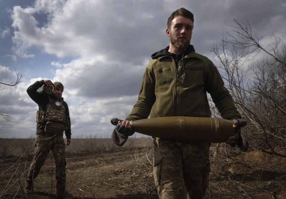 FILE - Ukrainian soldiers carry shells to fire at Russian positions on the front line, near the city of Bakhmut, in Ukraine's Donetsk region, on March 25, 2024. The outgunned and outnumbered Ukrainian troops are struggling to halt Russian advances as a new U.S. aid package is stuck in Congress. (AP Photo/Efrem Lukatsky, File)