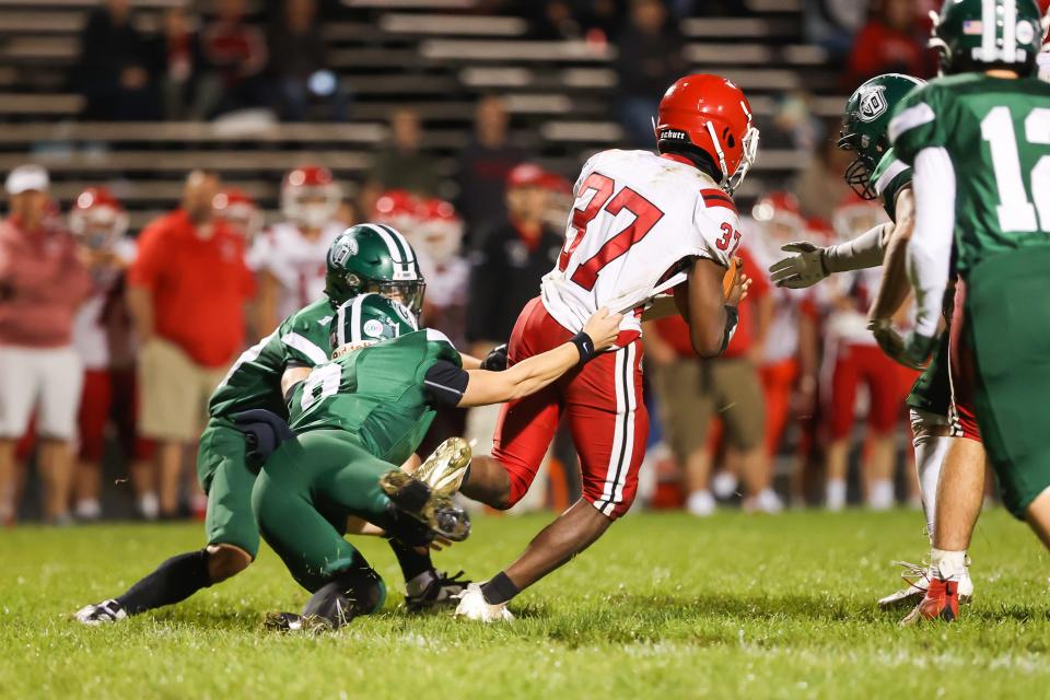 Spaulding's Ty Nicholson tries to break away from Dover's Cooper Gagne (9) and Tony D'Andrea (10) during Friday's Division I football game.