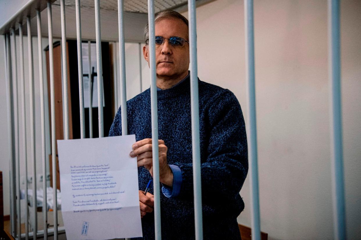 Paul Whelan holds a message as he stands inside a defendants' cage before his latest hearing in Moscow: AFP/Getty