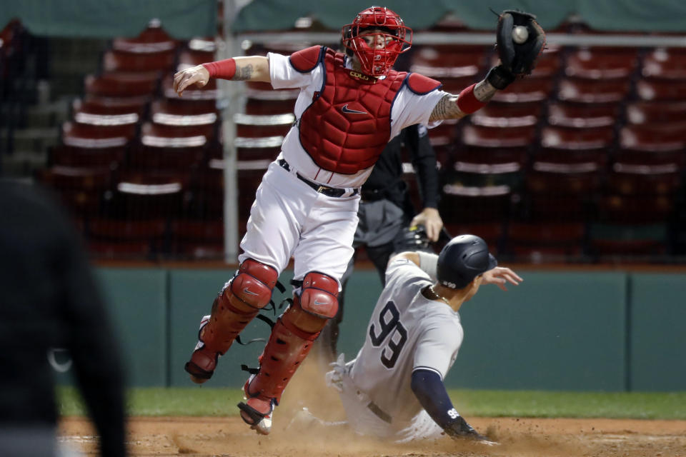 New York Yankees' Aaron Judge (99) scores ahead of the throw to Boston Red Sox catcher Christian Vazquez on a double by Giancarlo Stanton during the eighth inning of a baseball game Friday, Sept. 18, 2020, in Boston. (AP Photo/Michael Dwyer)