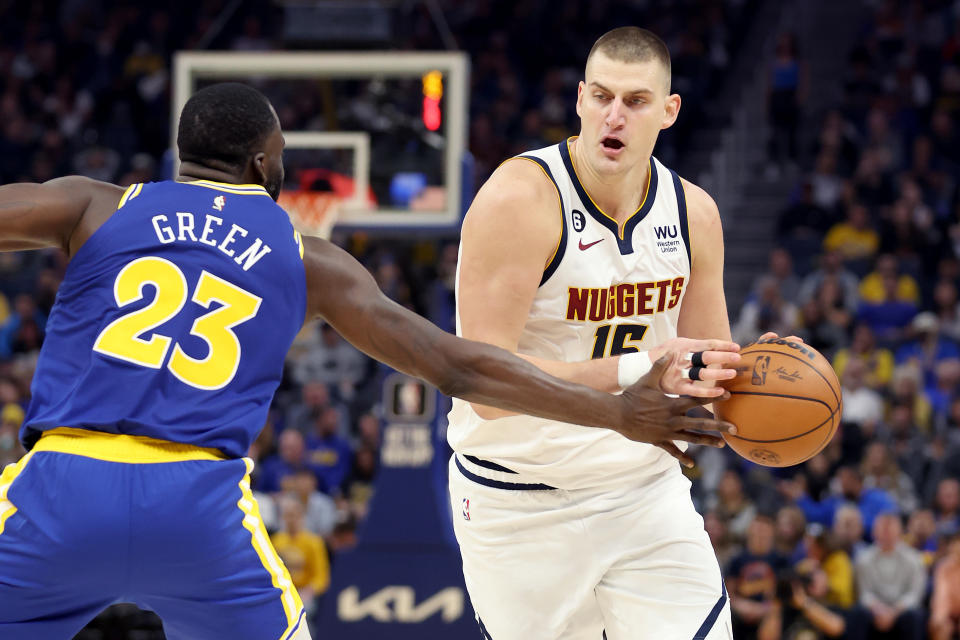 SAN FRANCISCO, CALIFORNIA - OCTOBER 21: Nikola Jokic #15 of the Denver Nuggets is guarded by Draymond Green #23 of the Golden State Warriors at Chase Center on October 21, 2022 in San Francisco, California. NOTE TO USER: User expressly acknowledges and agrees that, by downloading and or using this photograph, User is consenting to the terms and conditions of the Getty Images License Agreement.  (Photo by Ezra Shaw/Getty Images)