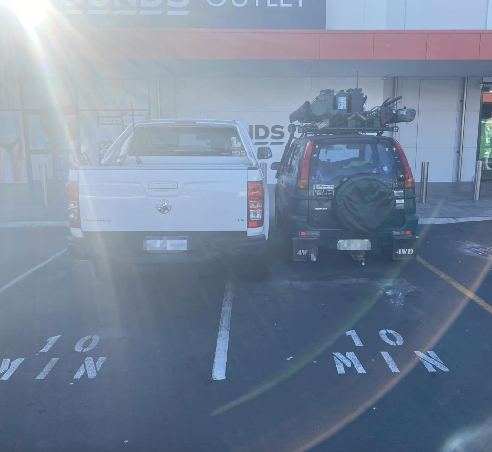 The two cars parked very close together.