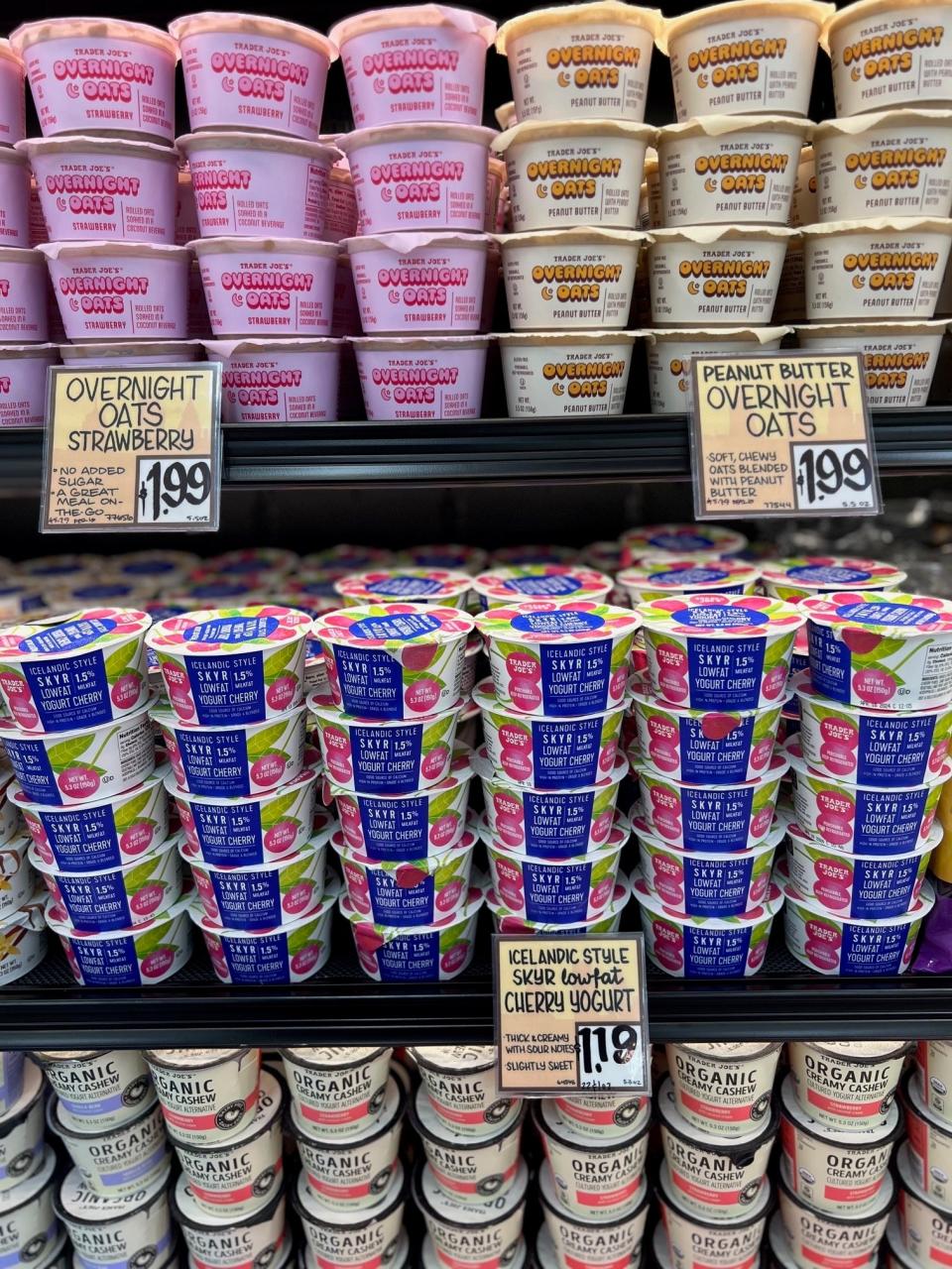 Shelves stocked with various flavors of yogurt and overnight oats in a grocery store