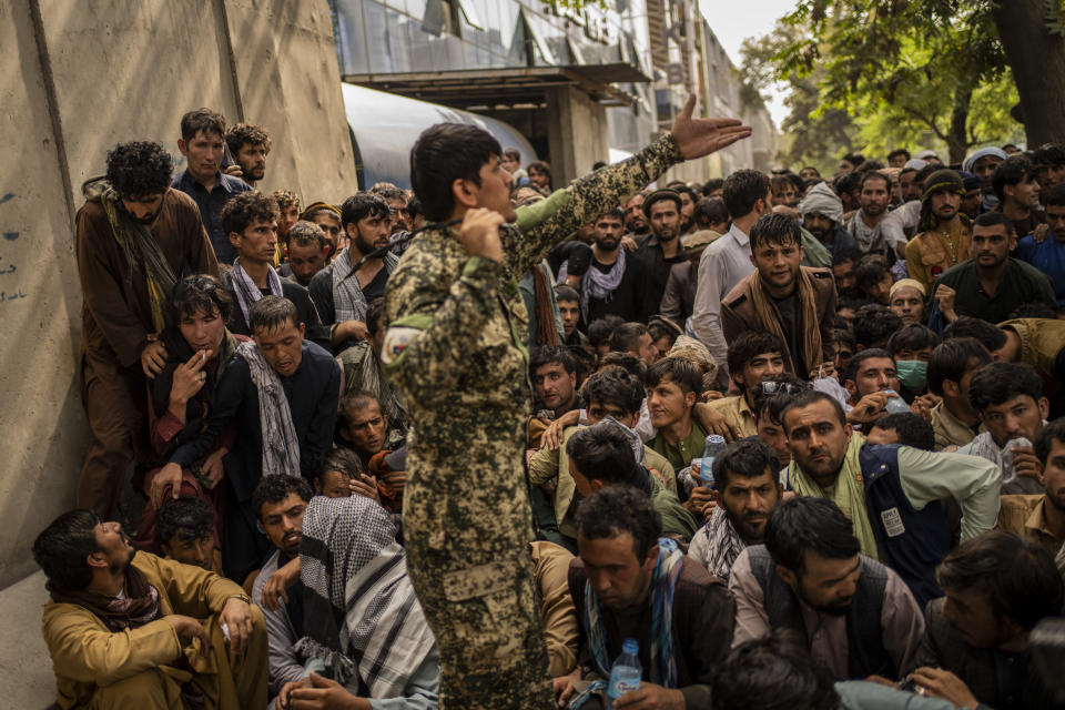 Afghans wait in front of a bank as they try to withdraw money in Kabul, Afghanistan, Sunday, Sept. 12, 2021. (AP Photo/Bernat Armangue)