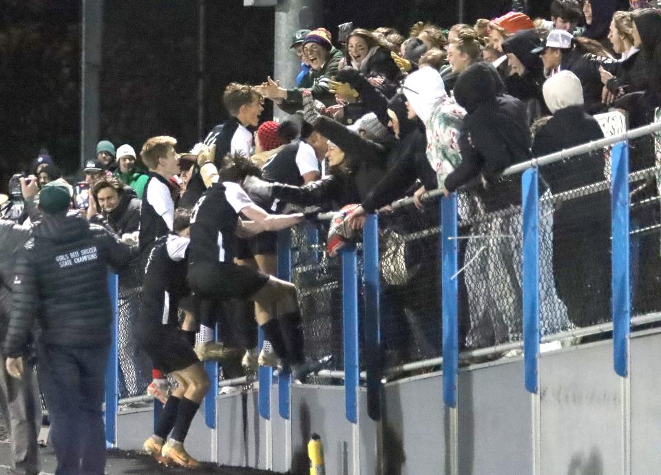 The Stowe Raiders jump into the stands after their 3-0 win over Peoples Academy in the D3 State Championship game on Friday night at South Burlington's Munson Field.