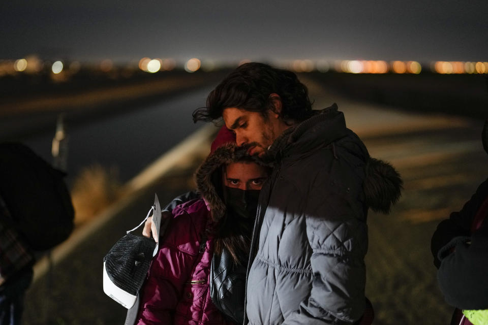 FILE - Cuban migrant Mario Perez holds his wife as they wait to be processed to seek asylum after crossing the border into the U.S. near Yuma, Arizona, Jan. 6, 2023. (AP Photo/Gregory Bull, File)
