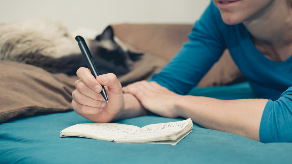 person writing in notebook