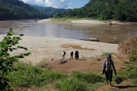 Journalists and researchers walk up to Ban Sob Moei, a Thai village located at the confluence of Moei and Salween rivers, which is threatened by the planned Hatgyi dam in Myanmar November 16, 2014. REUTERS/Thin Lei Win/File Photo