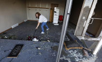 <p>Stephanie Moz, of Marshalltown, Iowa, cleans out her tornado-damaged business on Main Street, Thursday, July 19, 2018, in Marshalltown, Iowa. Several buildings were damaged by a tornado in the main business district in town including the historic courthouse. (Photo: Charlie Neibergall/AP) </p>