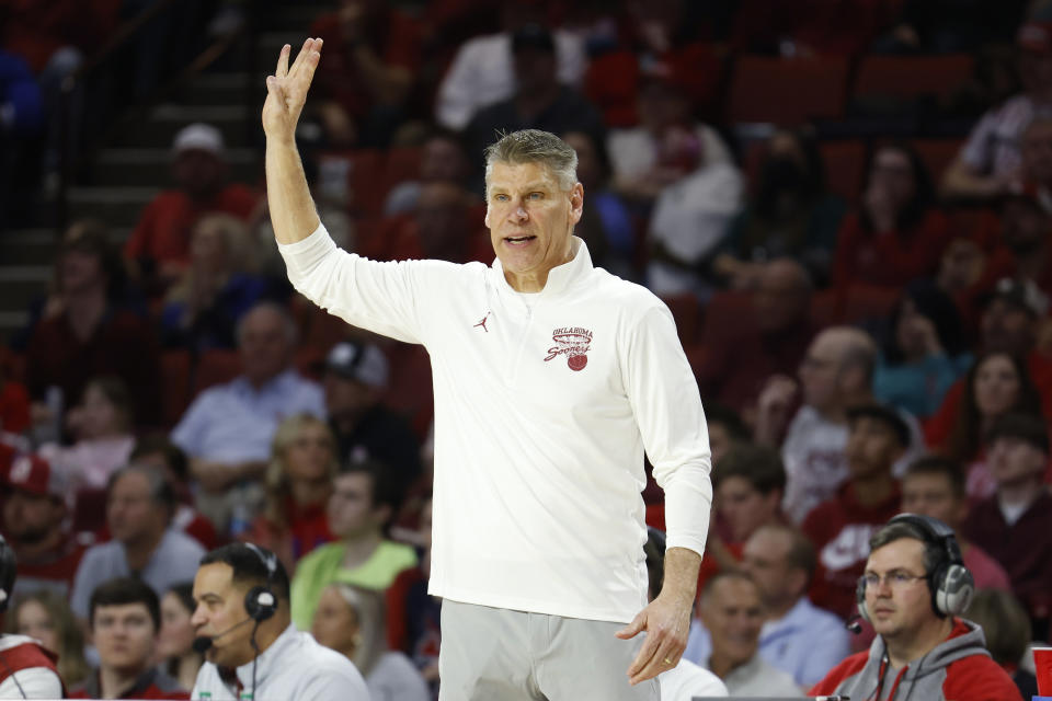 Oklahoma Porter Moser signals from the sideline during the second half of an NCAA college basketball game against Kansas, Saturday, Feb. 17, 2024, in Norman, Okla. (AP Photo/Garett Fisbeck)