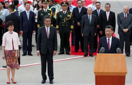 Chinese President Xi Jinping speaks after his arrival at the airport in Hong Kong, China, as Hong Kong Chief Executive-elect Carrie Lam and Hong Kong Chief Executive Leung Chun-ying listen ahead of celebrations marking the city's handover from British to Chinese rule, June 29, 2017. REUTERS/Bobby Yip