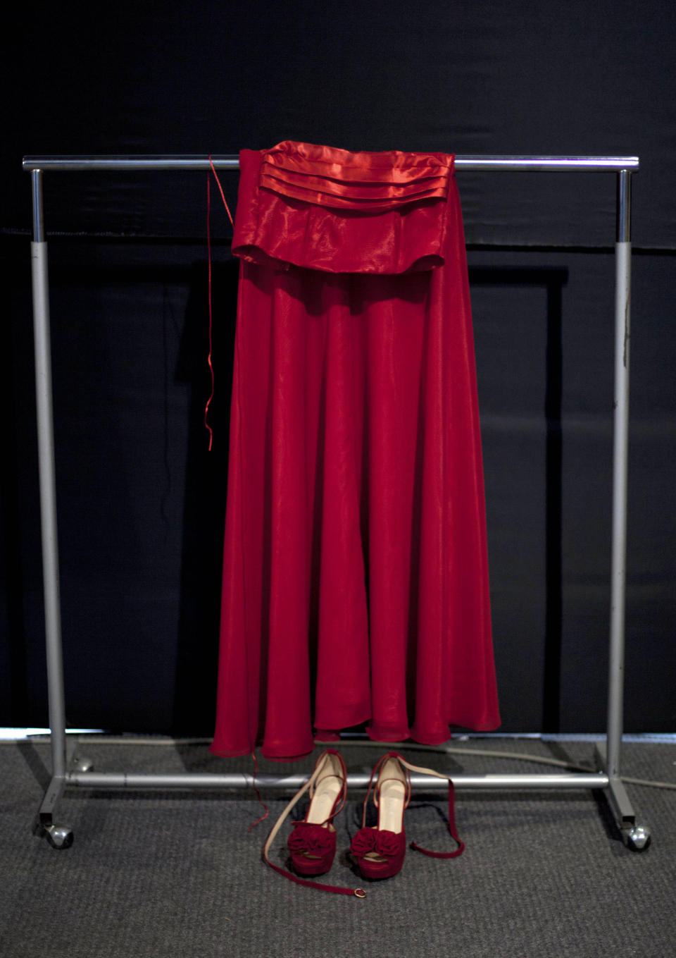 In this April 9, 2013 photo, a red dress and shoes by Peru's Moda & Cia. sit backstage prior to the show during Lima Fashion Week in Lima, Peru. The shows are highlighting the work of 16 Peruvian designers of clothes, jewelry and accessories as well as the collection of Spanish designer Agatha Ruiz de la Prada, who was invited as a special participant. (AP Photo/Martin Mejia)