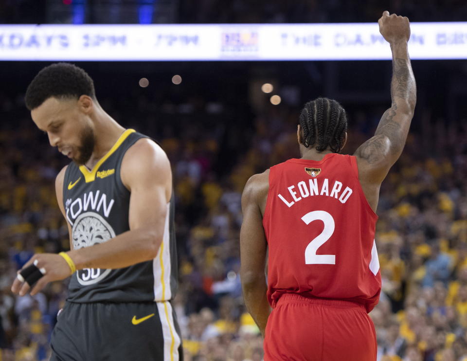 Toronto Raptors' Kawhi Leonard raises his fist following a basket as Golden State Warriors' Steph Curry walks away during the second half of Game 6 of basketball’s NBA Finals, Thursday, June 13, 2019, in Oakland, Calif. (Frank Gunn/The Canadian Press via AP)