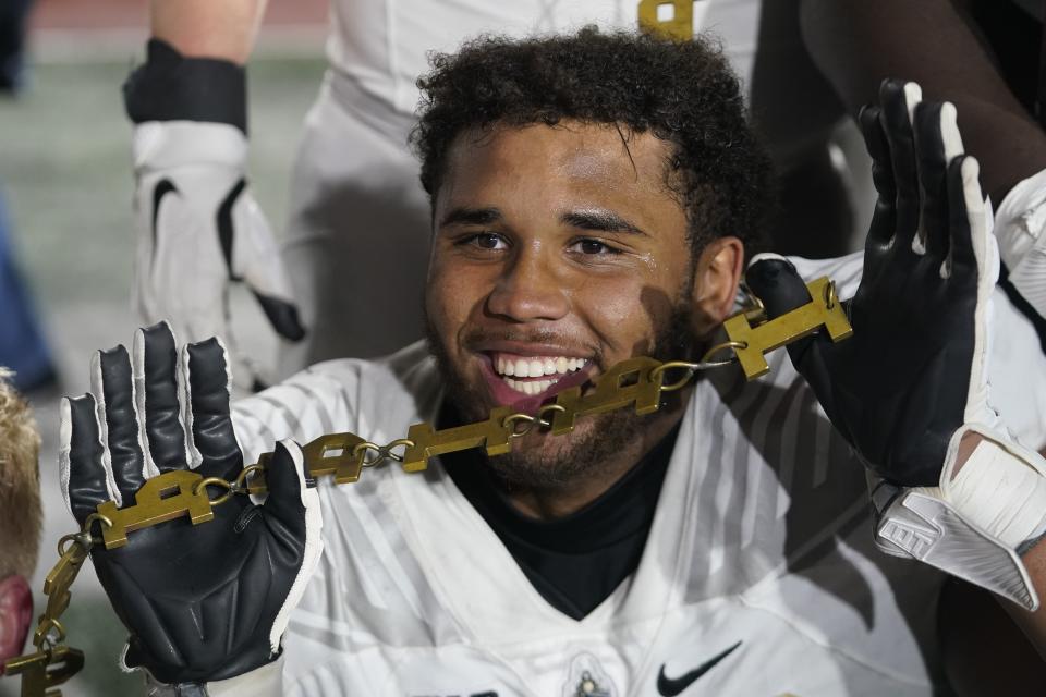 Purdue's Marcus Mbow holds a chain as he celebrates after Purdue defeated Indiana in an NCAA college football game, Saturday, Nov. 26, 2022, in Bloomington, Ind. (AP Photo/Darron Cummings)