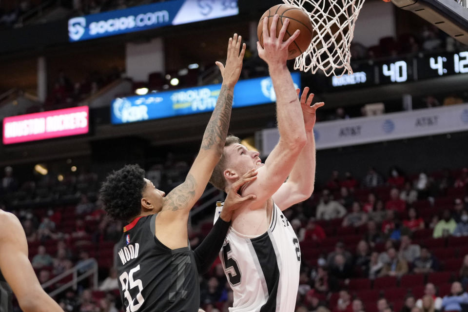 San Antonio Spurs center Jakob Poeltl, right, shoots as Houston Rockets center Christian Wood defends during the first half of an NBA basketball game, Tuesday, Jan. 25, 2022, in Houston. (AP Photo/Eric Christian Smith)