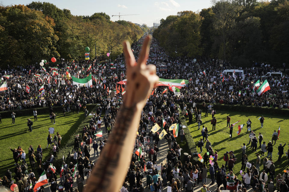 A man gestures as people attend a protest against the Iranian regime, in Berlin, Germany, Saturday, Oct. 22, 2022, following the death of Mahsa Amini in the custody of the Islamic republic's notorious "morality police". The 22-year-old died in Iran while in police custody on Sept. 16 after her arrest three days prior for allegedly violating its strictly-enforced dress code. (AP Photo/Markus Schreiber)