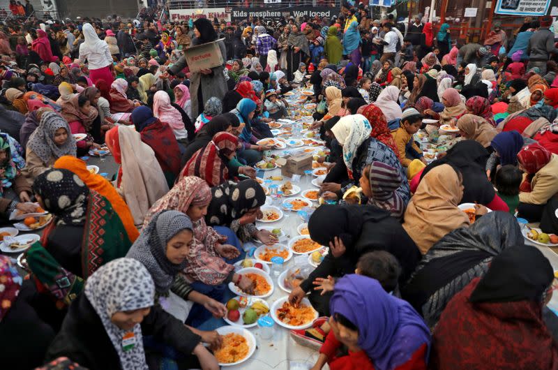 Local residents break their day-long fast as they attend a protest against a new citizenship law, in New Delhi