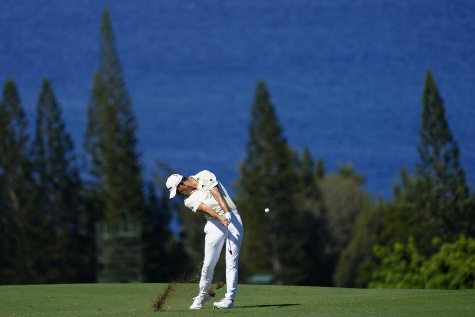 FILE - Collin Morikawa hits from the fairway on the fourth hole during the first round of the Tournament of Champions golf event, Jan. 6, 2022, at Kapalua Plantation Course in Kapalua, Hawaii. Morikawa is among players helping contribute to local charities in response to the deadly fires in Lahaina. (AP Photo/Matt York, File)