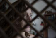 Carolina Wolf, who dances with Venezuela's national ballet, poses for a photo after her training session in her living room, during a lockdown to curb the spread of COVID-19 in Caracas, Venezuela, Tuesday, Aug. 11, 2020. The 42-year-old ballerina said her living room is four times smaller than the studio where she practiced daily at the famed Teresa Carreño Theater, and she doesn't dare do jumps in fear of injuring herself on the hard floor. (AP Photo/Ariana Cubillos)