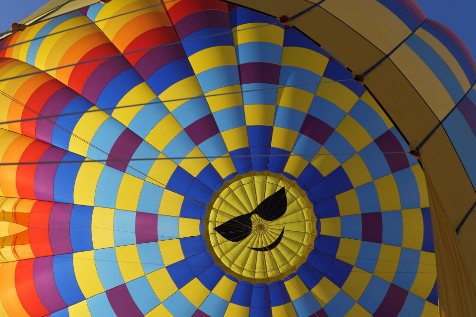 A smiling face is seen inside a Napa Valley Aloft balloon, in Yountville, Calif., Monday, June 19, 2023. This year, wine grapes are thriving after a winter of record amounts of rain fell in California, but a recent trip high above the valley in a hot air balloon revealed miles of lush, green vineyards — the only blemish coming from shadows cast by the balloons themselves. (AP Photo/Eric Risberg)