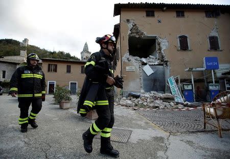 Firefighters walks in front of a collapsed building after an earthquake in Visso, central Italy, October 27, 2016. REUTERS/Max Rossi