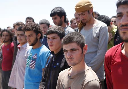 Islamic State prisoners, who were pardoned by a council that is expected to govern Raqqa once the group is dislodged from the Syrian city, stand in Ain Issa village, north of Raqqa, Syria June 24, 2017. REUTERS/Goran Tomasevic