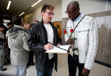 Paul Mattson (L) and Roland Smith fill out paperwork as they stand in line for a marriage license at the Oakland County Courthouse, after a Michigan federal judge ruled a ban on same-sex marriage violates the U.S. Constitution and must be overturned, in Pontiac, Michigan March 22, 2014. REUTERS/Rebecca Cook