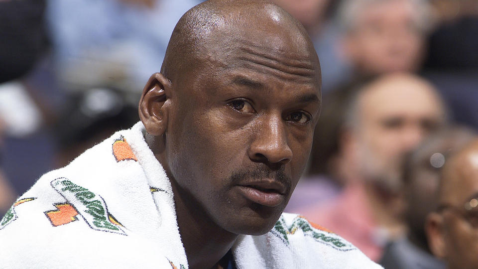 Michael Jordan looks on as he sits on the bench during a game against the Houston Rockets.